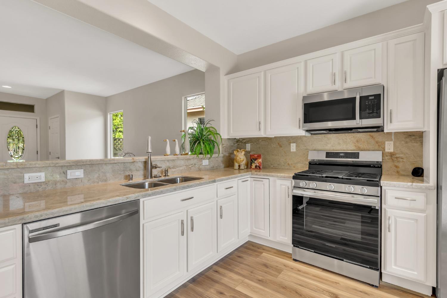 Kitchen with Stainless Steel appliances & quartzite counter tops & backsplash