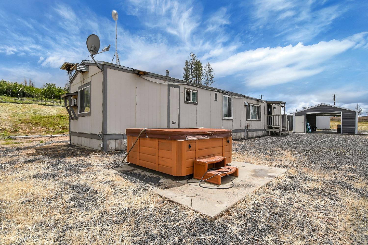 This property has stunning views.  Manufactured home on a permitted, permanent foundation. Three garages, and 18x31, an 18X26, and a 10X20.  Garages are metal and meticulously maintained, and fully permitted. This would be great for the car enthusiast. There is a Built in pool, and a spa.  The manufactured needs work. There is another shed that was going to be an ADU, still could be.  Well irrigation to garden area. Video surveillance to property. Exterior stadium lighting. You could live in this home and build your dream home. More photos coming.