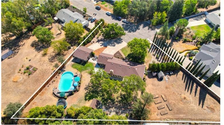 Nestled on a cul-de-sac on .89 acre, this beautiful ranch style 1-story w/ 2 2-car garages, a 20' x 40' pool, room for a horse corral & only 1 owner, is a must see! Whole house fan, radiant barrier, newer roof, new water heater & ceiling fans. Charming curb appeal w/ a long driveway & double doors w/ screen doors. Entry w/ chandelier. Formal living room w/ vaulted ceiling & formal dining room w/ chandelier. Gathering room w/ fireplace & nook. Kitchen w/ peninsula island w/ counter seating & newer faucet. Double doors lead to a large owner's suite w/ a vaulted ceiling, 2 closets w/ organizers & slider to a deck w/ pergola. Large owner's bath w/ updated 2 sink vanity. Secondary bath w/ newer vanity & framed mirror. 2-car garage & 2-car detached garage/shop w/ sink, cabinetry & work bench. Palatial backyard w/ mature trees, new patio w/ stamped concrete, 7 ft deep sunken in above ground pool w/ deck, garden boxes & 2 sheds. Low property taxes, no Mello Roos & no HOA. 7 mi. to HWY 99.