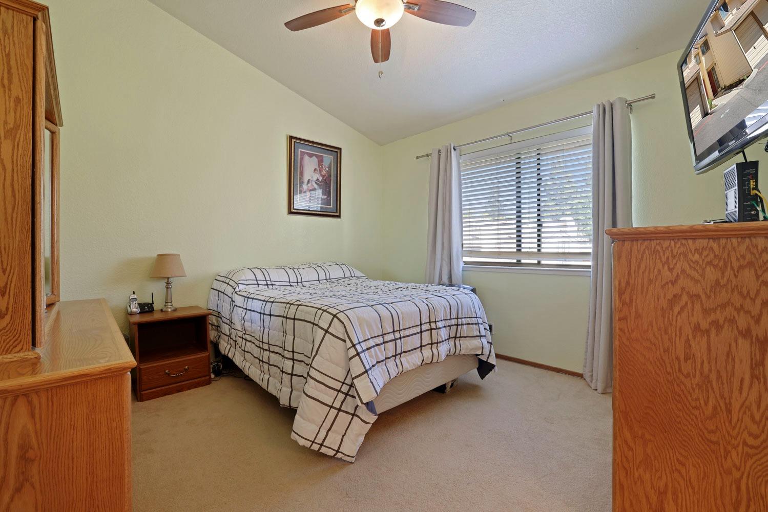 Photo #10 Spacious Primary Bedroom has cathedral ceilings and a beautiful fan to circulate the cool air in the evenings.