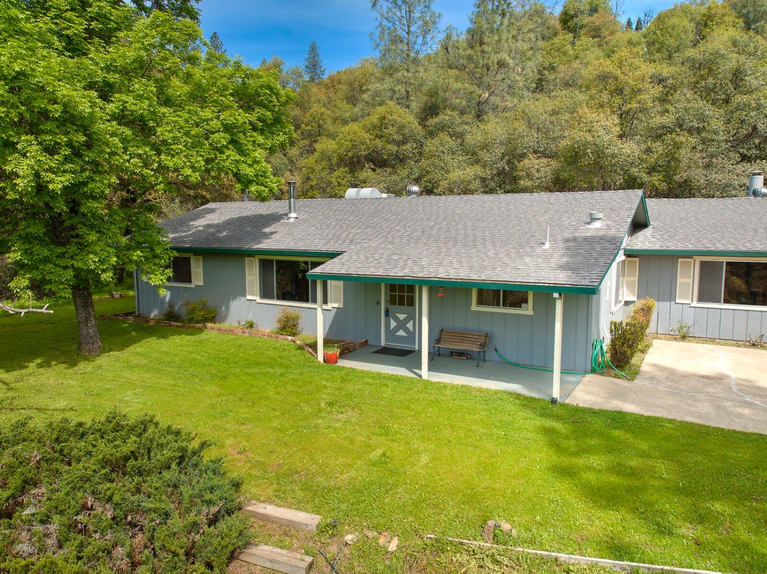 This charming 1820sf ranch-style home on 3.49 acres in beautiful Placerville is minutes from Main St and Hwy 50 but gives you the space and beauty of a rural property and is only 2 mins from Lions Park. Ample parking for cars and toys. Multiple outbuildings include a 2-car garage, chicken coop, and garden shed. Past the fenced backyard is a trail among the trees that presents a natural, almost-hidden waterfall and huge rock boulders. From the front porch, look across the grassy yard to an open meadow below and while outside you can enjoy watching the planes from the  Placerville airport nearby. Touches of vintage charm throughout the home include detailed, artistic diagonal wood-paneling in the front living room, where the wood stove can provide alternative heat to this cozy room and beyond. The spacious family room past the kitchen is perfect for using as a big game room, children's playroom, spacious light-filled office or whatever your imagination can bring. Enjoy the convenience of an indoor laundry room off of the kitchen. Some of the original amenities like the kitchen cabinets have been maintained by the seller through the years to remain in good function and condition. This is a great home that allows for some buyer touches to make it your own and increase your equity.