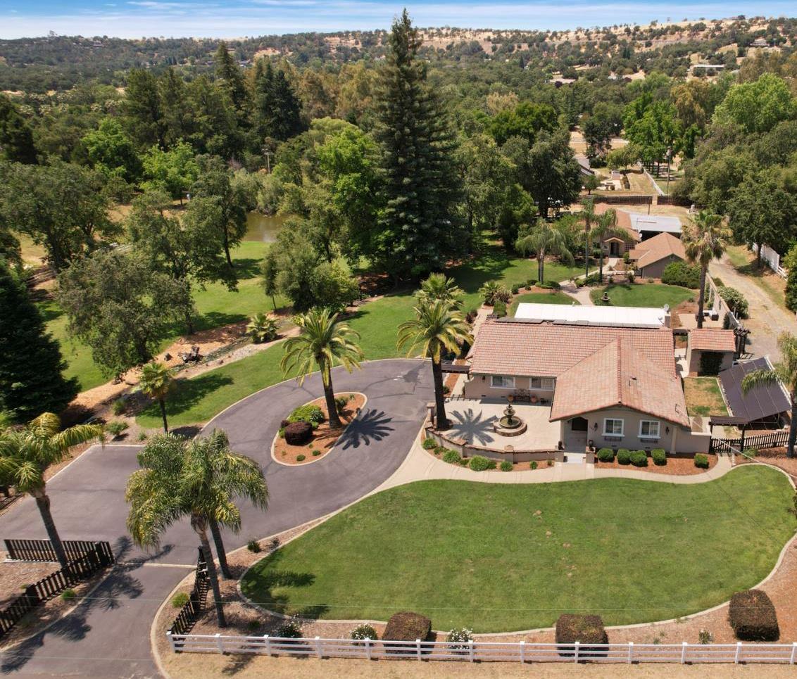 5407 Butler Road Penryn, California Truly remarkable property consisting of a gorgeous Tuscan Mediterranean style home, 2006sqft shop with ADU plans, oversized 2 car garage, 2 ponds, a year round natural spring on 3.5 flat useable acres, perfect for any entertainer looking for an excuse to be proud to host any event. The main home at 2190sqft with an open concept design exemplifies Old World Tuscan design with modern amenities, and at the heart of the home is a chef's kitchen including top of the line stainless steel appliances. Fine finishes and pride of ownership flourish throughout, including smooth imperfect walls, wood floors, crown molding and coffered ceilings in the dining room, granite counters in kitchen, travertine tile, archways inlayed with travertine, beautiful columns, LED lighting, ADA accessibility, lots of alder stained cherry soft close cabinets, updated bathrooms with marble counters, custom faucets and finishes. The property is equipped with a total of 53 OWNED solar panels, with Wifi Enphase system. Overlook the stunning property and ponds from the covered patio while enjoying the outdoor BBQ/Kitchen with granite counters, Spa, and plenty of additional space for a full outdoor living experience. The shop is large and contains additional living space with kitchen and full bath. Got to see