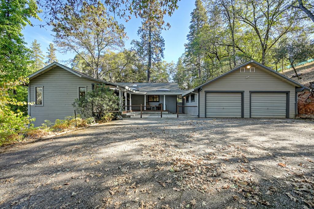 Updated, single-story Eden Valley/Colfax home is nestled on 2 picturesque acres bordered by a bubbling creek.  Interior finishing touches include sought-after knockdown drywall texture, bullnose edging, and new alderwood panel doors throughout, beautifully highlighting the home's maple, hardwood flooring. The inviting great room showcases a new Jotul wood-burning stove and has direct access to an expansive deck where you can take in the tranquil natural surroundings.  A spacious, light-filled kitchen centers around a sleek granite island, and the surrounding perimeter soft-close cabinets are hardware-free and frame a premium, flush-mounted stainless steel Bosch dishwasher and refrigerator.  Floor-to-ceiling pantry cabinets are conveniently located in the adjoining laundry room (washer and dryer included), with a granite folding counter, sink, and 1/2 bath.   Unwind in the spacious owner's suite featuring, vaulted ceilings, a walk-in closet, a spa-like ensuite, and direct access to the back deck.  The recently replaced front porch entrance features sidelights, can lighting, and expanded covered decking with an adjoining enclosed patio area.  Important improvements are already in place, including a 40-year composition, roof replacement in 2010,  redwood decking, new HVAC and a new water heater.  An oversized 2-car garage offers abundant storage and plenty of room for a workshop, hobbies, or projects.   The driveway is paved and has a designated gravel parking area for an RV with a power hookup. Adding even more possibilities is a cozy, 1-room cottage with woodstove heat located at the entrance of the property.  A nice option for an office or hobby space.  Enjoy the spacious, partially fenced yard with a kids' play area and a tiered multi-use garden area with new-start fruit trees, apple, cherry, and figs.  A peaceful setting that invites you to relax under the redwoods. Enjoy the serenity of country living while remaining conveniently close to I-80.  Approximately one hour from Lake Tahoe. Outdoor recreation is right at your doorstep, with the Bear River just minutes away and endless hiking opportunities throughout Auburn, Colfax, and Grass Valley.  Bring your vision and discover everything this special property offers. Check out nearby Dog Bar Bridge trailhead and swimming holes!